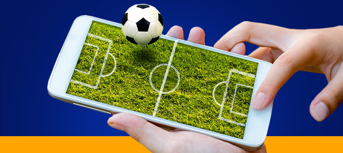 Imagem mostra mão utilizando smartphone com ilustração de campo de futebol e uma bola em destaque