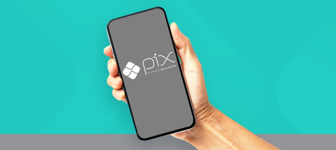 Imagem mostra mão segurando smartphone com PIX