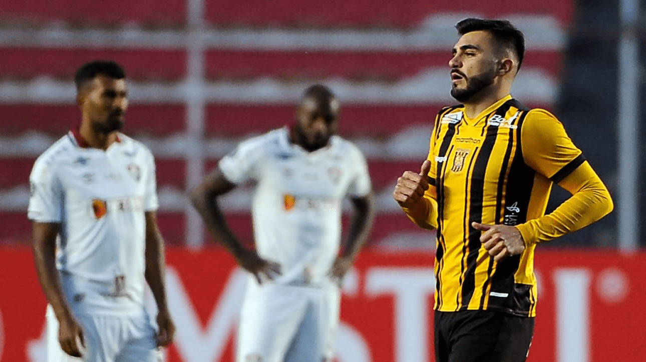Enrique Triverio comemorando gol. No fundo, jogadores do Fluminense lamentam (foto: Jorge Bernal/AFP)