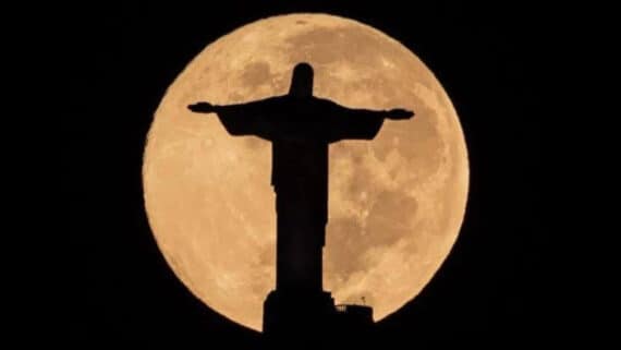 Cristo Redentor com as luzes apagadas e com a lua no fundo (foto: Reprodução Twitter)