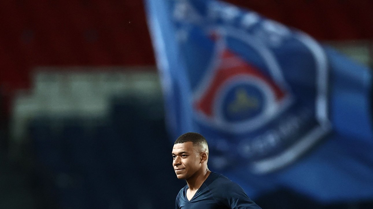 Mbappé e a bandeira do PSG ao fundo (foto: Anne-Christine POUJOULAT / AFP)