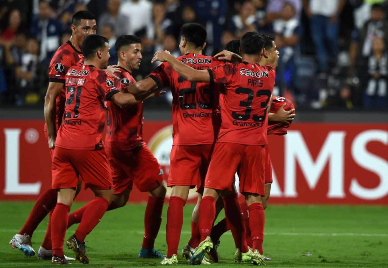 Jogadores do Libertad se abraçam em comemoração de gol contra o Allianza Lima (foto: Cris Bouroncle/AFP)