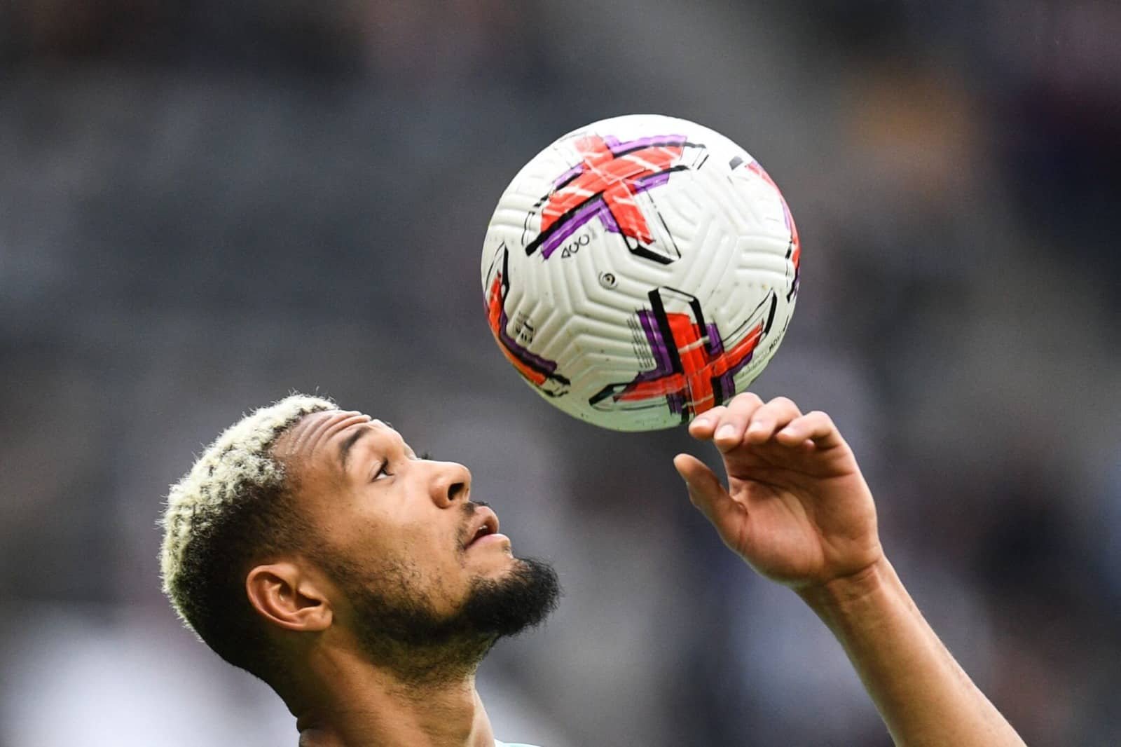 Foto mostra o jogador Joelinton, da Seleção Brasileira, equilibrando a bola (foto: Oli Scarf/AFP)