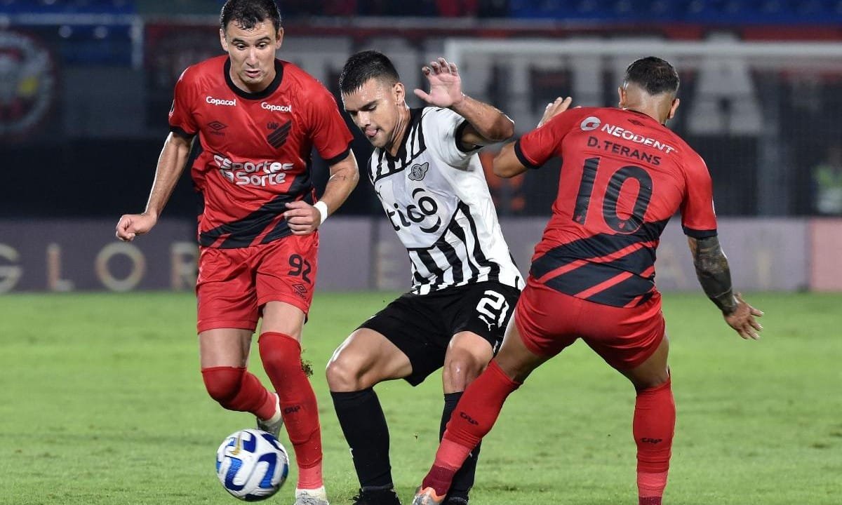 O meia uruguaio David Terans e o atacante brasileiro Pablo, do Athletico-PR, disputam a bola com o meio-campista paraguaio Lucas Sanabria, do Libertad. (foto: NORBERTO DUARTE/AFP)