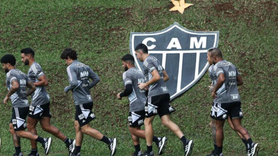 Jogadores correm em treino do Atlético-MG com escudo do clube ao fundo (foto: Pedro Souza/Atlético-MG)
