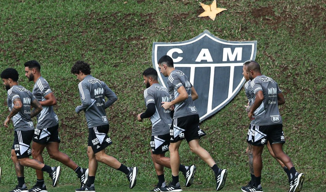 Jogadores correm em treino do Atlético-MG com escudo do clube ao fundo (foto: Pedro Souza/Atlético-MG)