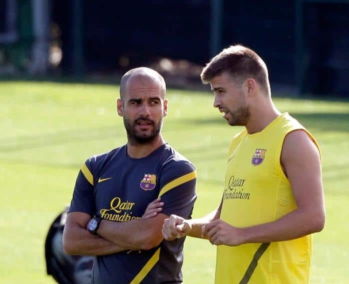 Guardiola e Piqué conversam durante treino do Barcelona (foto: Albert Gea/Reuters - 19/07/11)