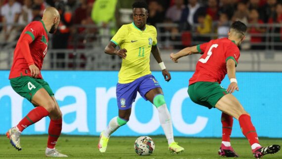 Vini Jr., atacante da Seleção Brasileira, é marcado por dois jogadores da Seleção Marroquina (foto: FADEL SENNA/AFP)