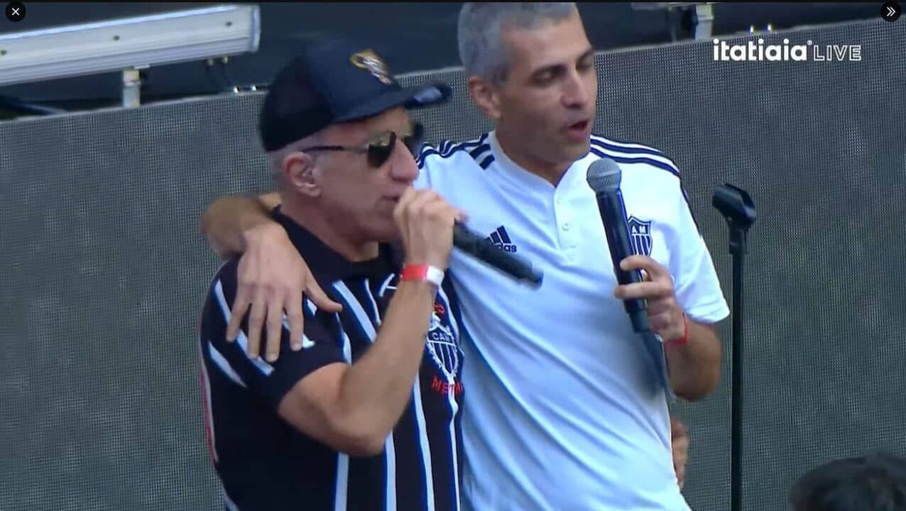 Jaime Júnior abraça Podé Nastácia que cantava o hino do Galo (foto: Reprodução/Itatiaia)
