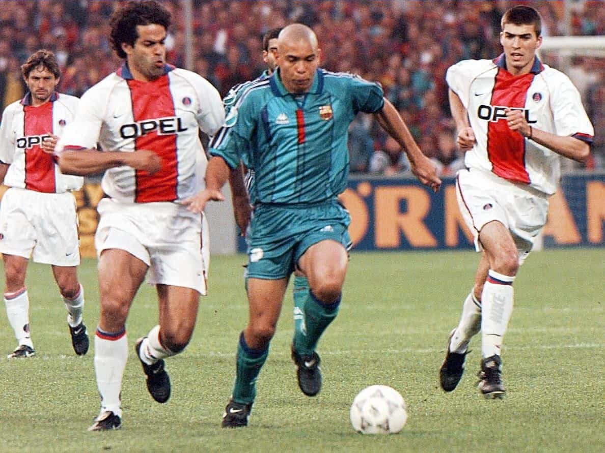 Ronaldo, pelo Barcelona, conduz a bola e é seguido por jogadores do PSG (foto: Gerard Cerles/AFP)