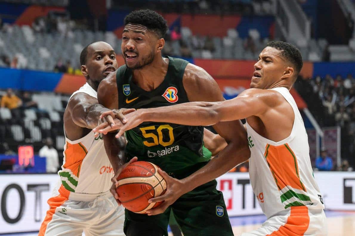 Jogadores de Brasil e Costa do Marfin em jogo da Copa do Mundo de Basquete, na Indonésia (foto: BAY ISMOYO / AFP)
