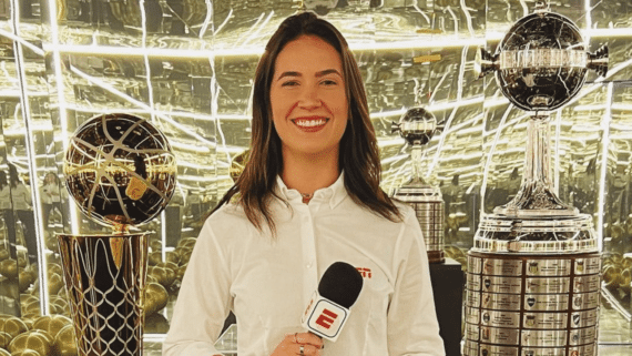 Mariana Spinelli sorrindo com microfone na mão ao lado da taça da Libertadores e da NBA (foto: Reprodução Instagram)