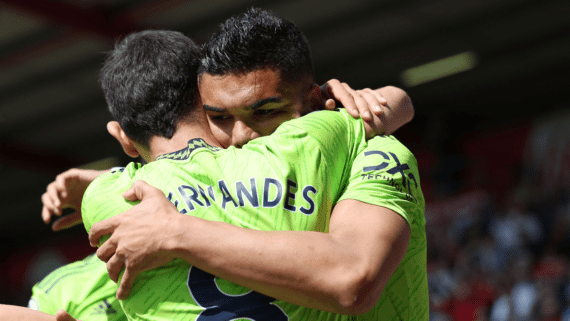 Bruno Fernandes e Casemiro se abraçando (foto: Adrian Dennis/AFP)