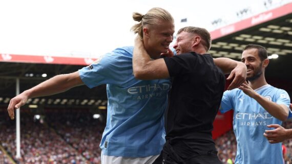 Torcedor e Haaland, em momento de invasão no campo (foto: Darren Staples/AFP
)