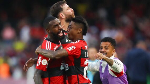 Gerson é abraçado por jogadores do Flamengo após gol contra o Coritiba (foto: Gilvan de Souza/Flamengo)