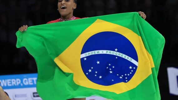 Rebeca Andrade segura bandeira do Brasil enquanto comemora (foto: Ricardo Bufolin/CBG)