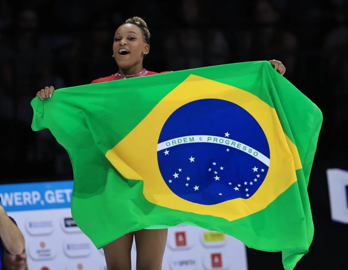 Rebeca Andrade segura bandeira do Brasil enquanto comemora (foto: Ricardo Bufolin/CBG)