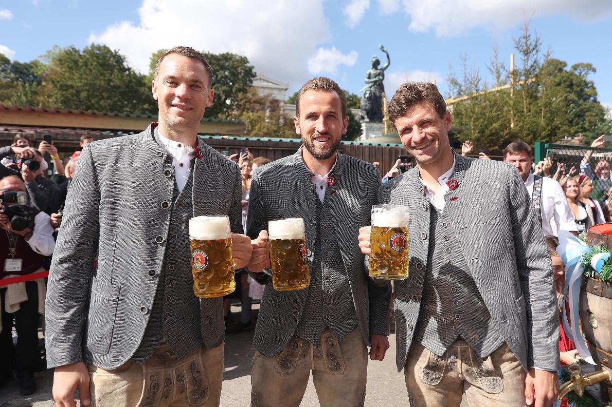 Neuer, Kane e Muller vestem roupas típicas na Oktoberfest, em Munique (foto: Alexander Hassenstein/AFP)