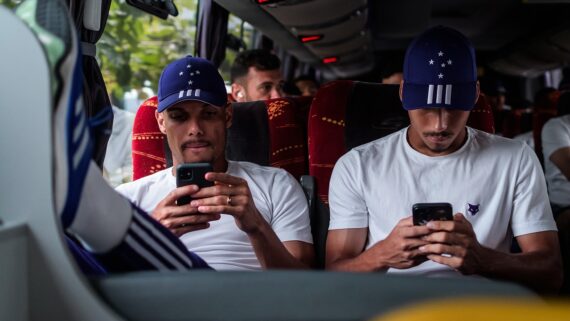 Jogadores do Cruzeiro mexendo no celular durante viagem de ônibus (foto: Gustavo Aleixo/Cruzeiro)
