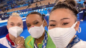 Sunisa Lee (à direita) desbancou Rebeca Andrade (ao centro) e ficou com o ouro na final do indivigual geral da Olimpíada de Tóquio - Crédito: 