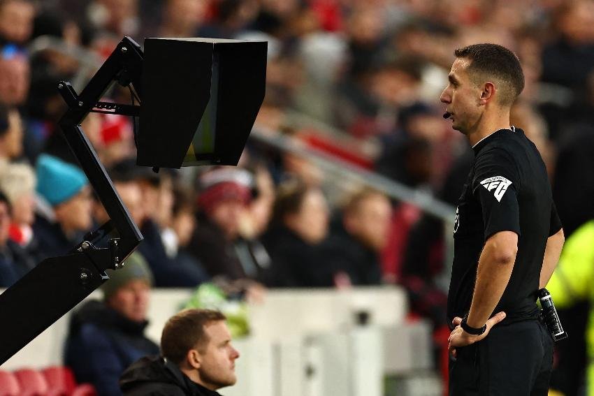 Juiz de olho no VAR (foto: HENRY NICHOLLS / AFP)