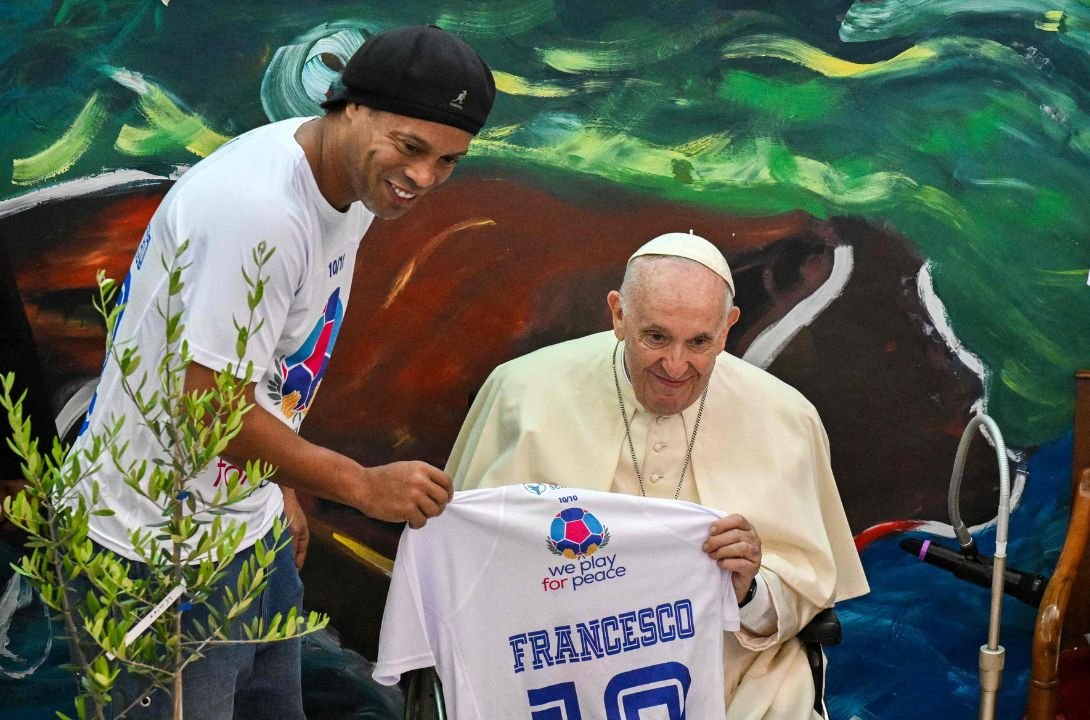 Ronaldinho ao lado do Papa Francisco (foto: Tiziana FABI / AFP)