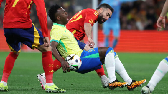 Vinícius Júnior é derrubado durante amistoso entre Seleção Brasileira e Espanha (foto: PIERRE-PHILIPPE MARCOU/AFP)