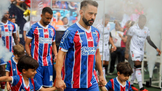 Everton Ribeiro entrando em campo de mãos dadas com duas crianças (foto: Tiago Caldas /EC Bahia)