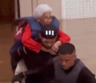 Thiago Maia carregando idosa nas enchentes (foto: Reprodução)