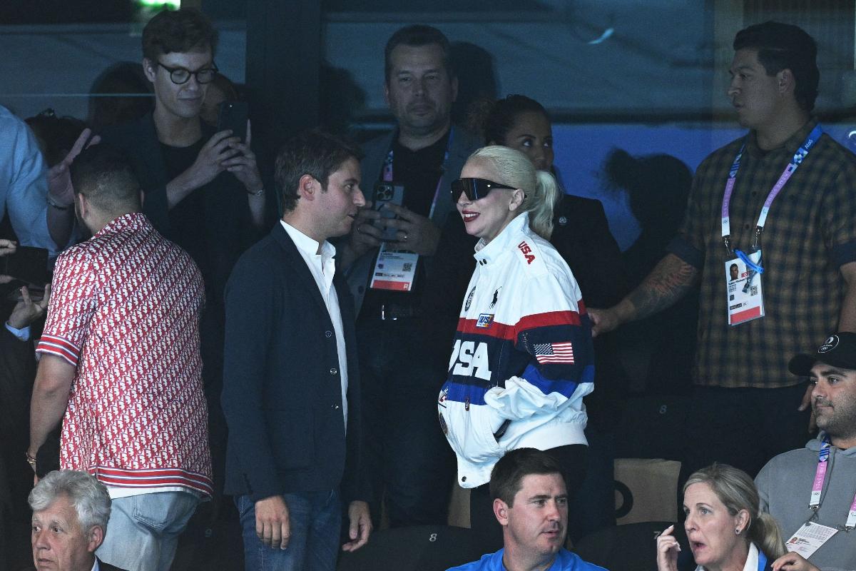 Lady Gaga conversa com homem em ginásio