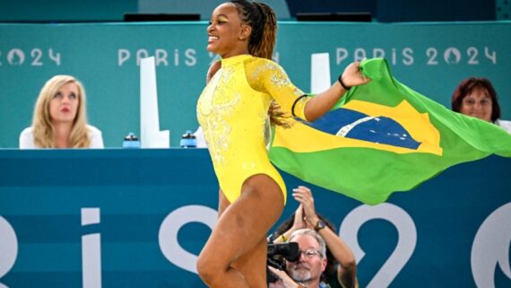 Rebeca Andrade corre com a bandeira do Brasil (foto: Leandro Couri/EM/D.A Press)