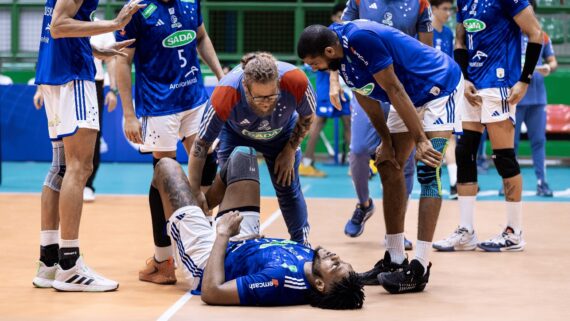 Central Cledenilson sendo atendido por médico do Cruzeiro enquanto outros jogadores o cercam (foto: Agência i7 / Cruzeiro)