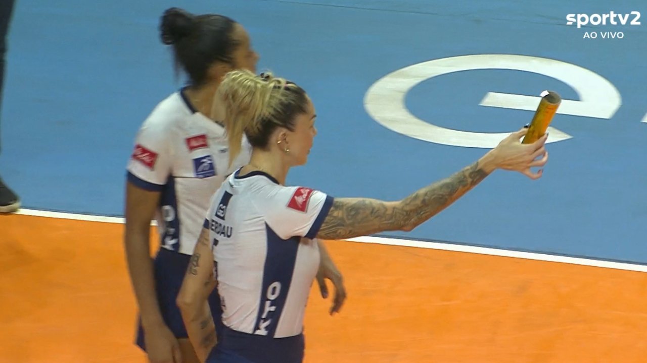 Thaísa com objeto arremessado pela torcida adversária na mão (foto: Reprodução/SporTV 2)