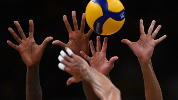 Mãos tentam bloqueio em jogada de vôlei com a bola da VNL (foto: Mauro Pimentel/AFP - 24/5/2024)