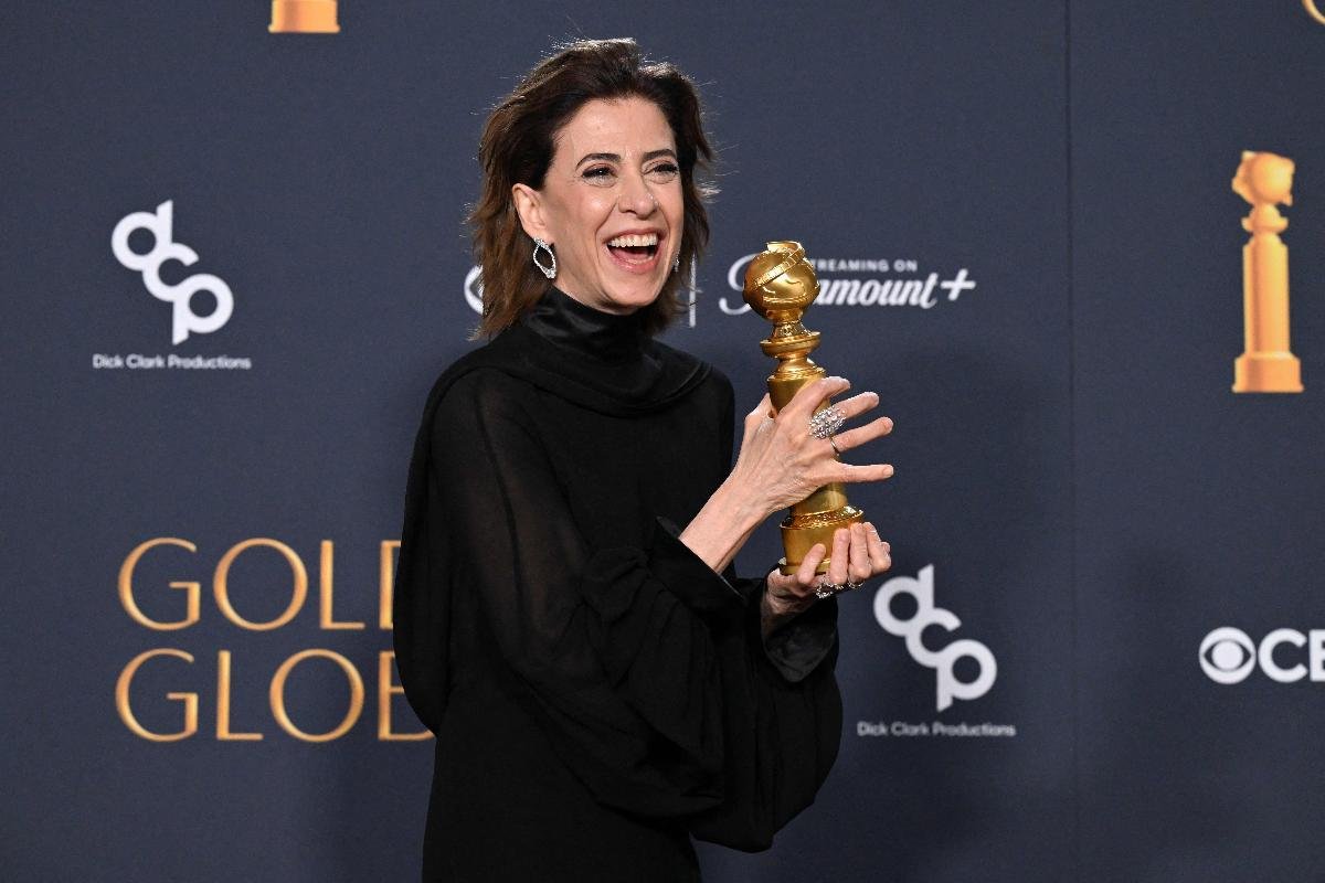 Fernanda Torres sorri e segura o prêmio de melhor atriz no Globo de Ouro (foto: ROBYN BECK/AFP)