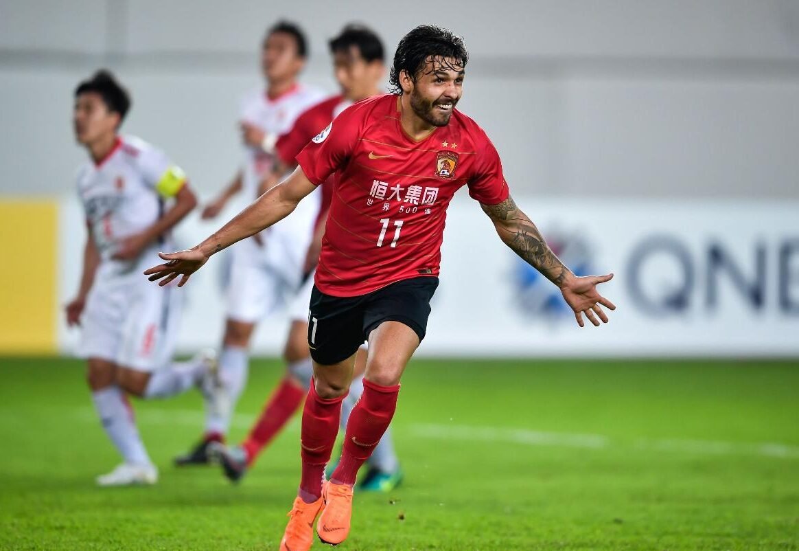 Ricardo Goulart corre com os braços abertos em jogo do Guangzhou (foto: AFP - 10/05/2020)