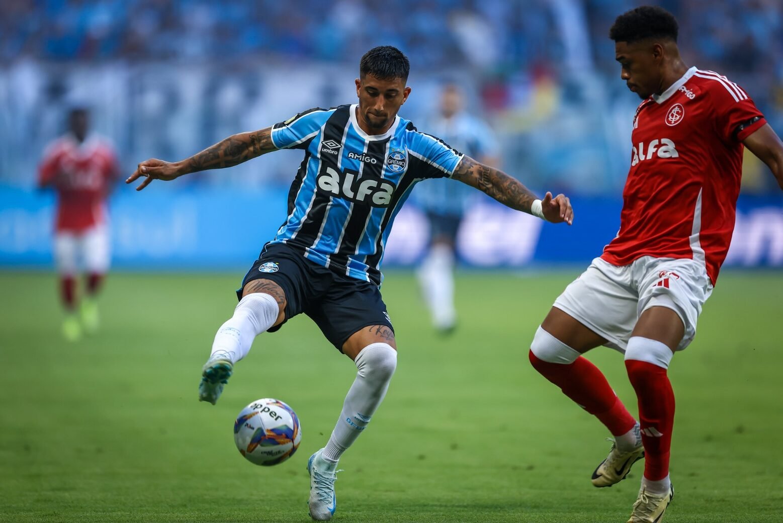 Jogador do Grêmio disputando bola com atleta do Internacional (foto: Lucas Uebel/Grêmio FBPA)