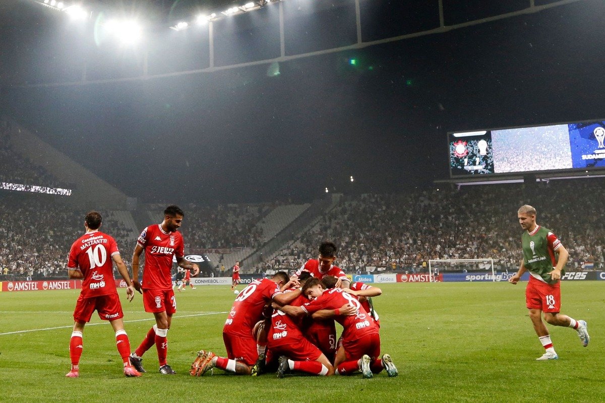 Jogadores do Huracán comemoram gol contra o Corinthians na Neo Química Arena (foto: Miguel Schincariol / AFP)