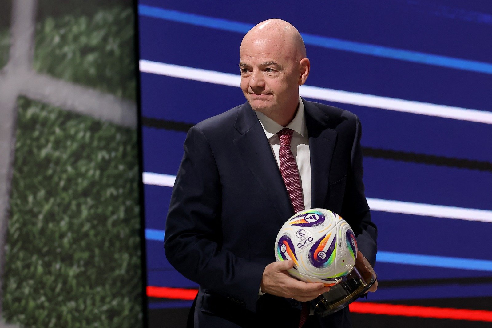 Gianni Infantino segurando uma bola (foto: Predrag Milosavljevic / AFP)