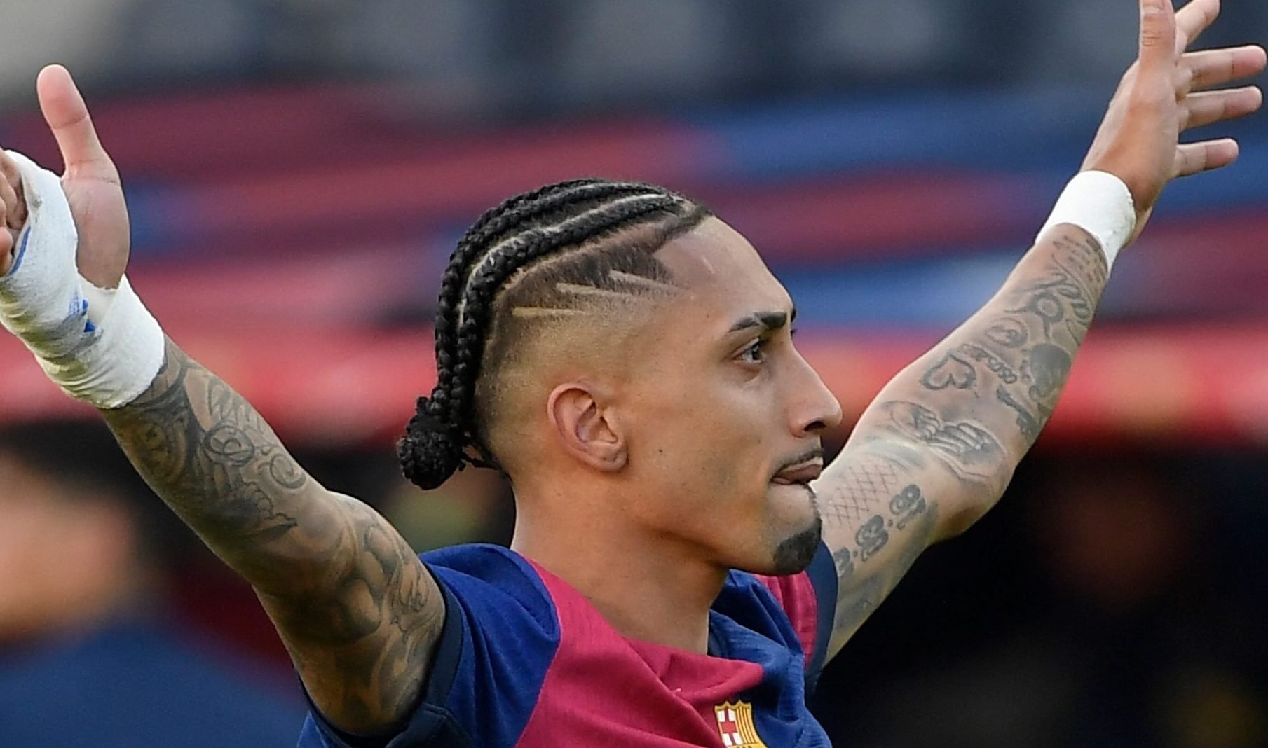 Raphinha celebra gol com braços abertos (foto: Josep Lago/AFP)