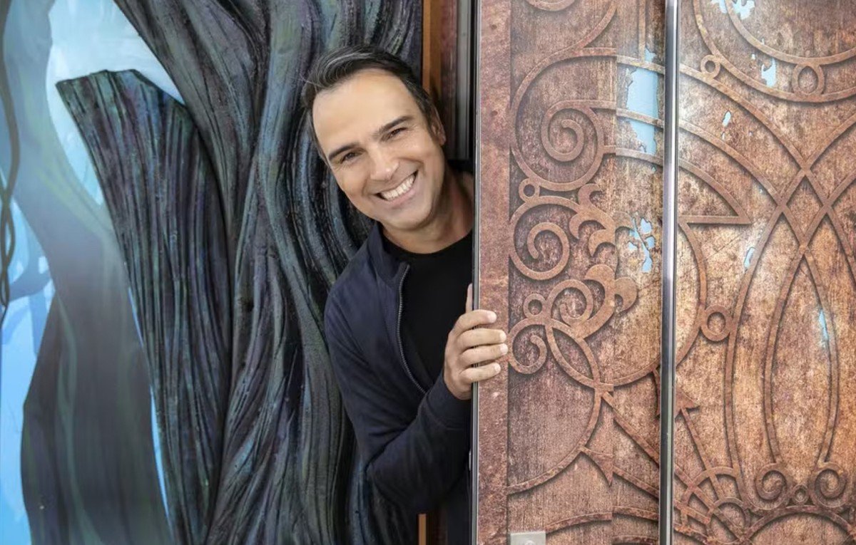 Tadeu Schmidt sorri ao abrir porta (foto: GShow/Reprodução)