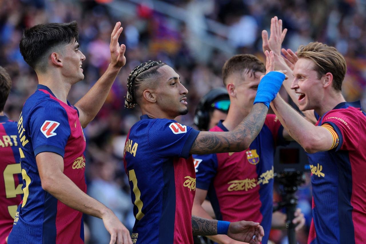 Jogadores do Barcelona se cumprimentando (foto: Lluis Gene / AFP)