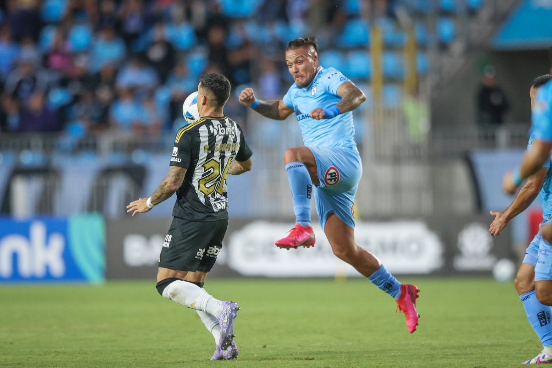 Saravia domina bola pelo Atlético, enquanto jogador do Deportes Iquique tenta desarmá-lo (foto: Pedro Souza/Atlético)