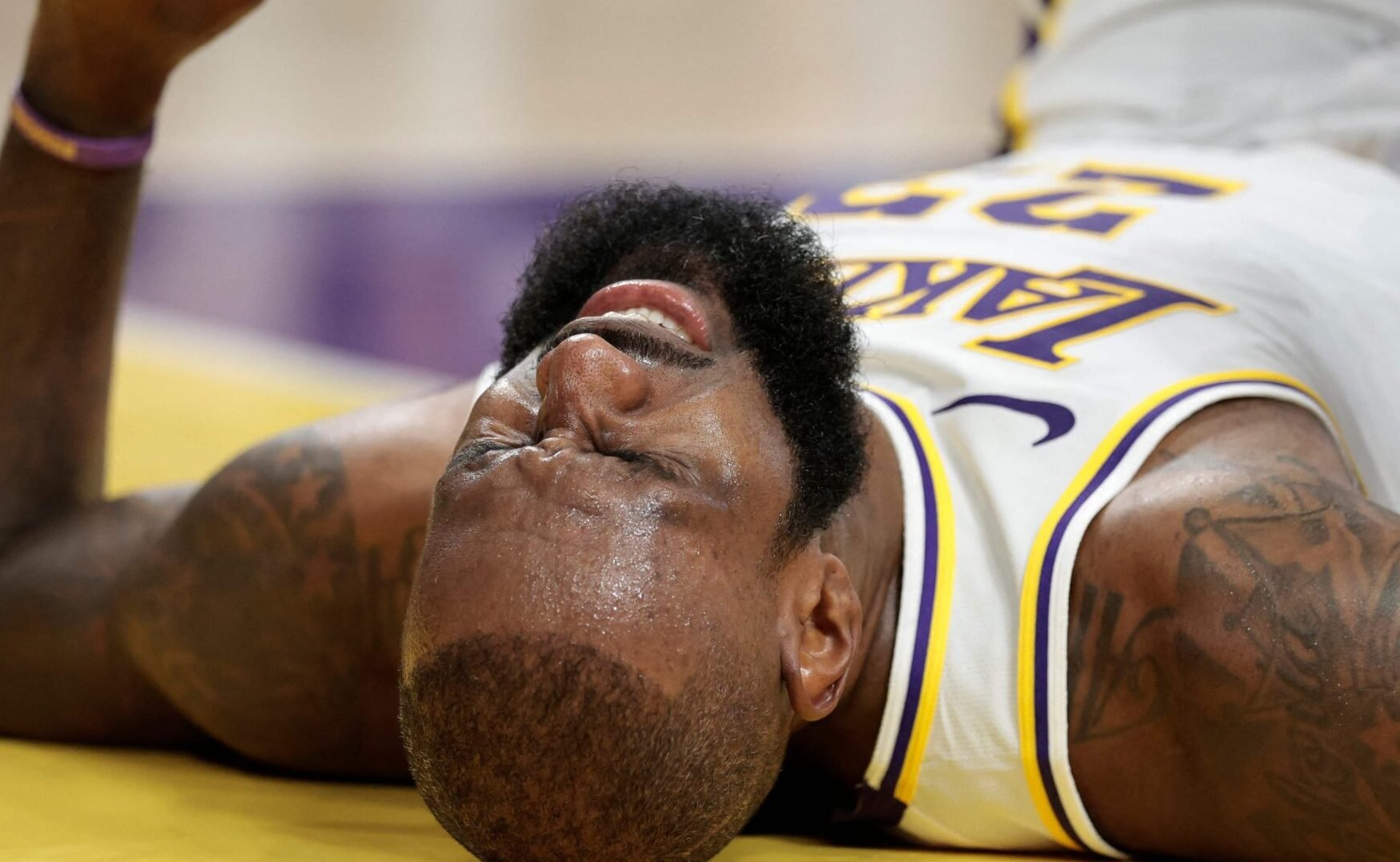 LeBron James caído em quadra com expressão de dor (foto: Ronald Martínez/AFP)