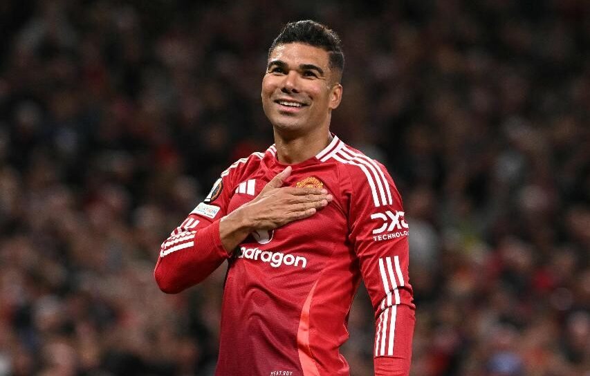 Casemiro com mão sobre escudo do united (foto: Oli Scarff / AFP)