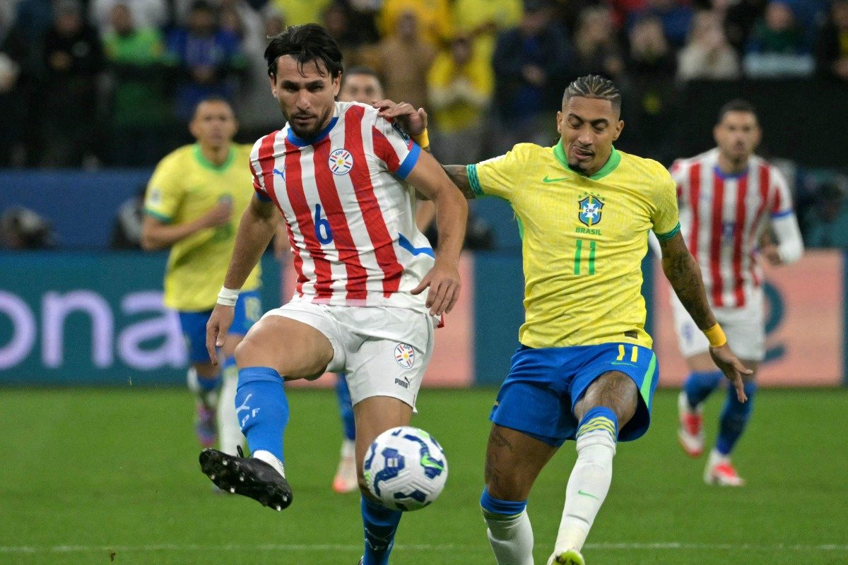 Alonso, do Atlético, divide bola com Raphinha durante Brasil x Paraguai (foto: NELSON ALMEIDA / AFP)