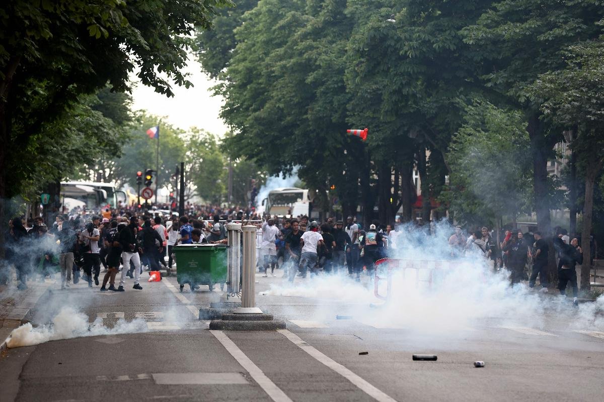 Imagem de conflito entre polícia e torcedores do PSG em Paris (foto: Romain Perrocheau/AFP)