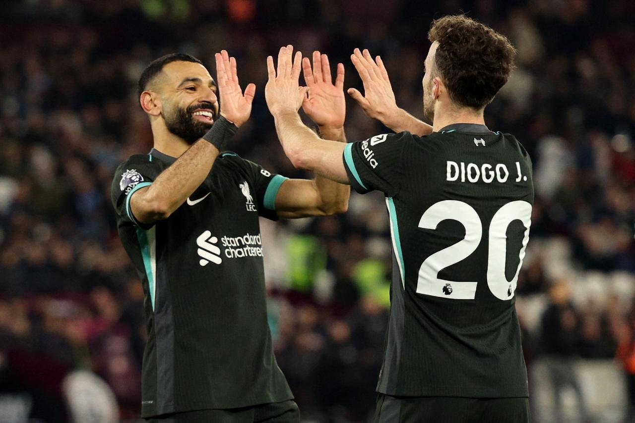 Salah e Diogo Jota se cumprimentam com as mãos em jogo pelo Liverpool (foto: Adrian Dennis/AFP - 29/12/24)