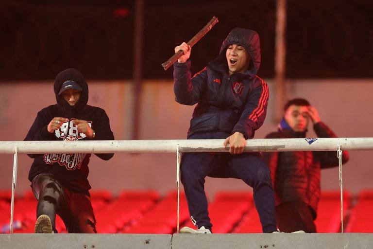 Torcedor do Universidad de Chile segura uma barra de ferro durante partida das oitavas de final da Copa Sul-Americana (foto: Alejandro Pagni/AFP)