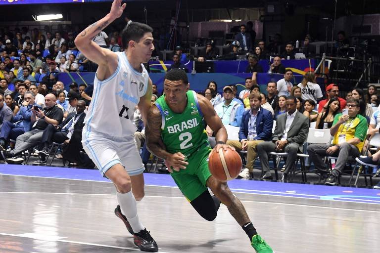 O brasileiro Yago Santos tenta passar pela marcação do argentino Jose Vildoza na partida deste domingo (foto: AFP)